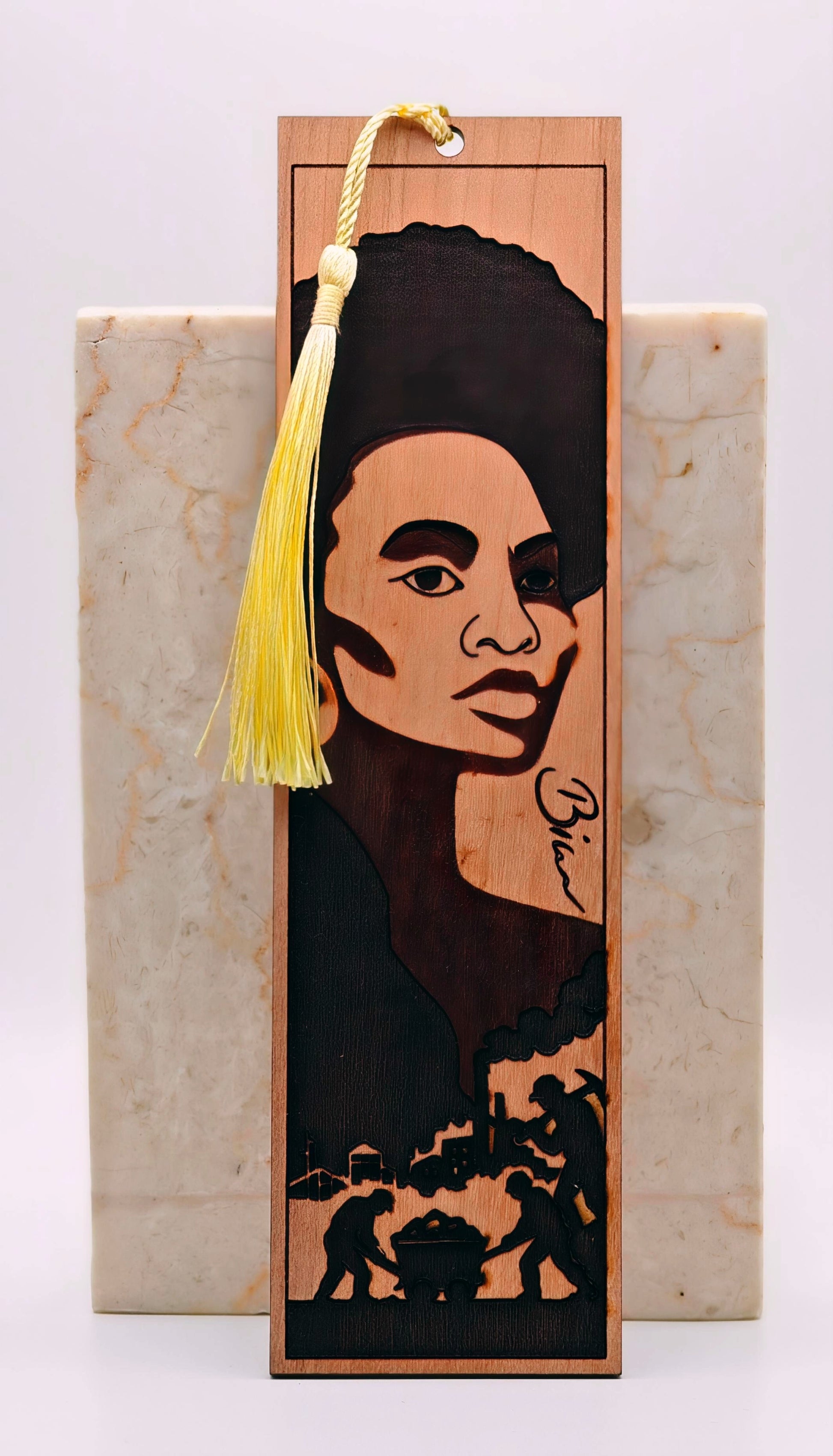 Wooden bookmark with a portrait of a woman and silhouettes on a marble surface